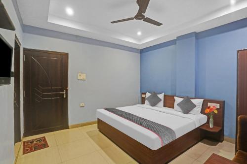 a bedroom with a bed with blue walls and a ceiling at Hotel O Dps Inn in Allahābād