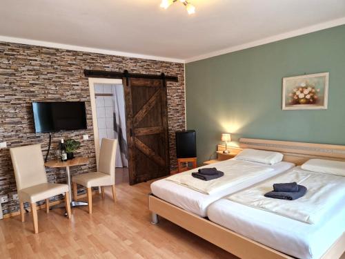 a bedroom with a large bed and a table and chairs at Waldpension Schiefling am See in Schiefling am See