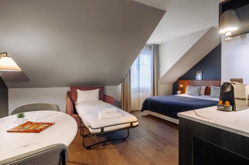 a hotel room with a bed and a couch at RockyPop Grenoble Hotel in Grenoble