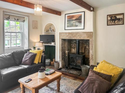 a living room with a couch and a fireplace at Emily's Cottage in Hebden