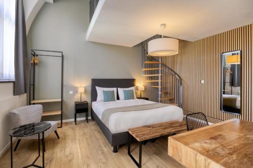 a bedroom with a bed and a table and a staircase at Beverly Hills Hotel in Brussels