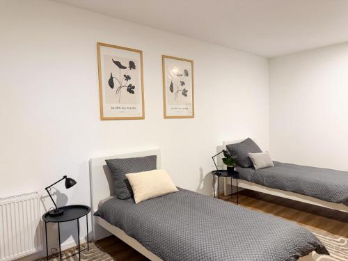 a bedroom with two beds and two pictures on the wall at Lucky Strike Hostel in Bad Oldesloe