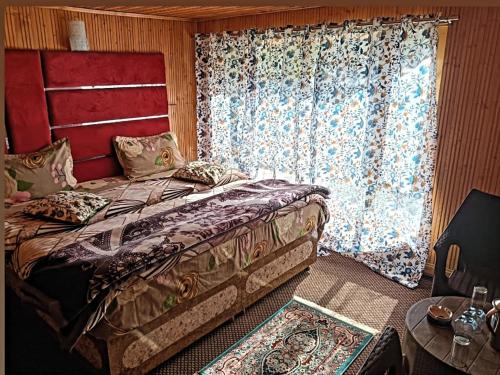 a bedroom with a large bed and a window at Hotel alpine resort pahalgam in Pahalgām