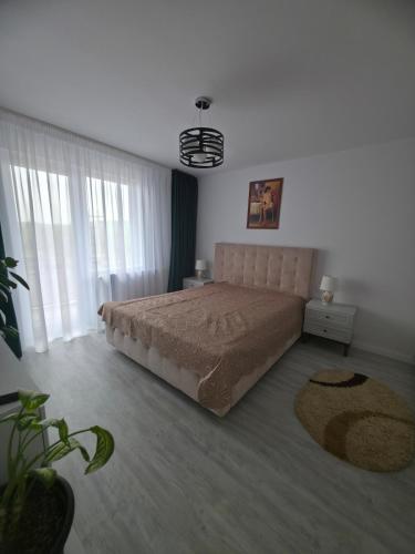 a bedroom with a bed and a large window at The Cozy Velvet in Ocna-Mureşului
