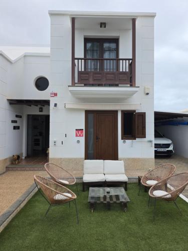 a house with two chairs and a couch on the grass at Refugio Costa Teguise - Lanzarote in Costa Teguise