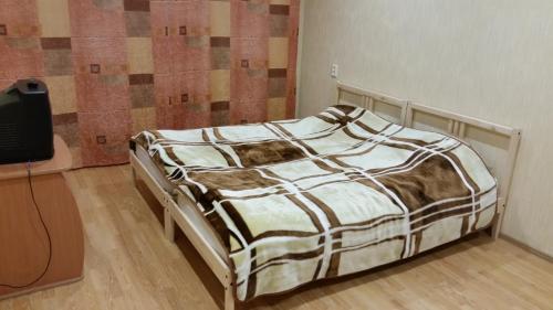 キロフスクにあるApartment on Sovetskoy Konstitutsiiのベッド(掛け布団付)が備わる客室です。