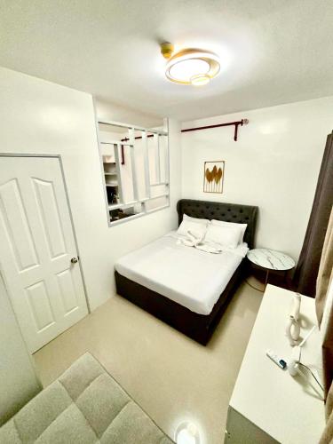 a small bedroom with a bed and a white door at The JOYful Stay in Mactan Island