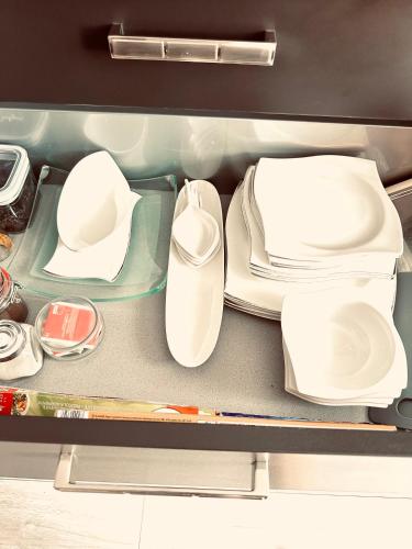 a drawer filled with white plates and utensils at Apartment klein, fein, ruhig und gemütlich in Bochum