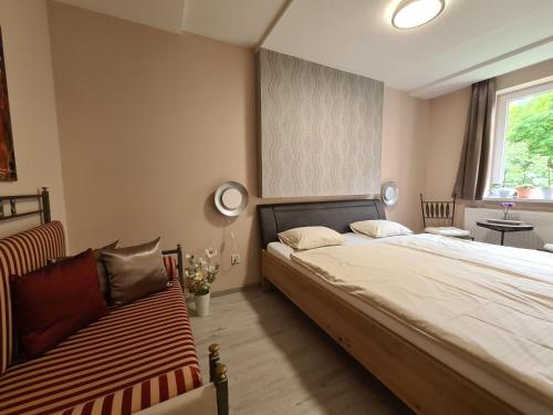 a bedroom with a bed and a bench in it at Götzer Apartman in Komló
