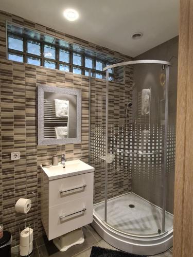a bathroom with a shower and a sink at Götzer Apartman in Komló