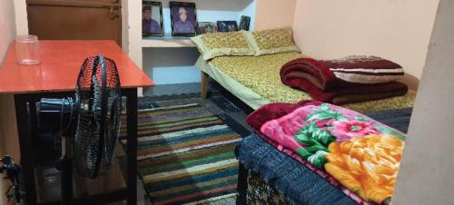 a room with a couch and a table with a blanket at Chaukhamba hill homestay in Ukhimath