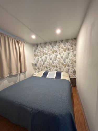 a bedroom with a blue bed in a room at El Moll Grec in L'Escala