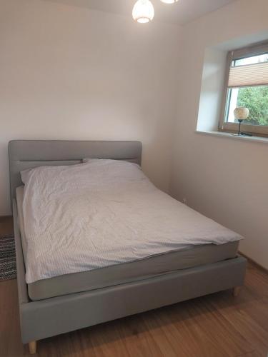 a bed in a white room with a bed frame at Miskant Apartamenty in Stary Karwno