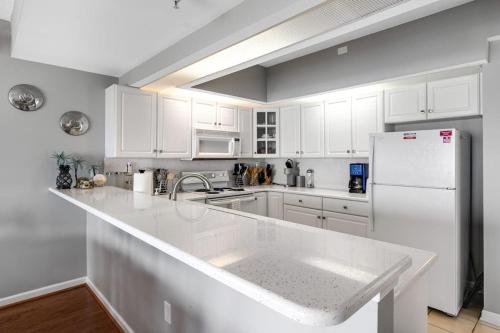 a kitchen with white cabinets and a white refrigerator at Playa Flamingo #302 in Ocean City