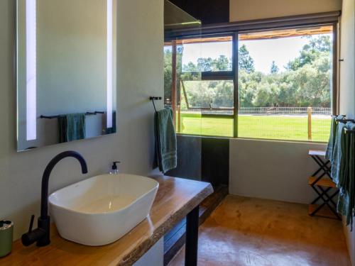 a large white tub in a bathroom with a window at Wild Olive Cottage with Hot tub in Wolseley