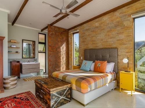 a bedroom with a bed and a brick wall at Mountain Bungalow private hot tub&swimming pool in Wolseley