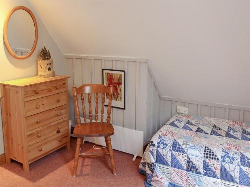 a bedroom with a bed and a chair and a dresser at Gareside Lodge in Rhu