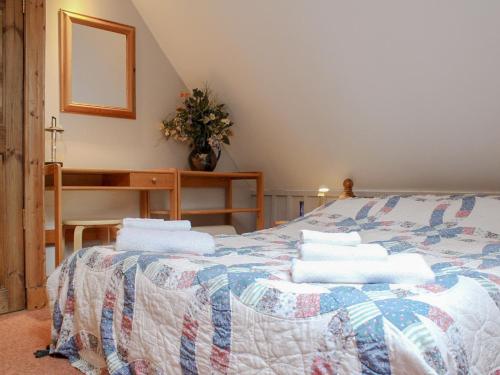 a bedroom with a bed with towels on it at Gareside Lodge in Rhu