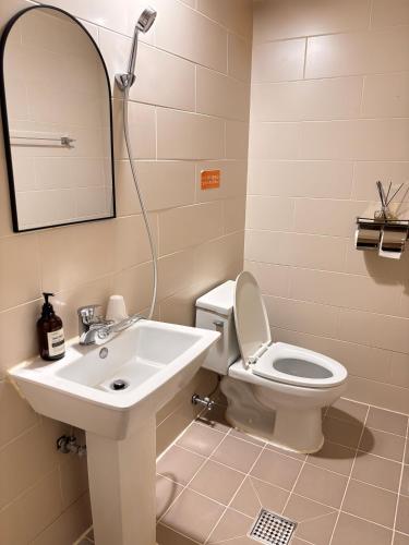 a bathroom with a sink and a toilet and a mirror at Hotel Amy in Pup'yŏng-yŏk