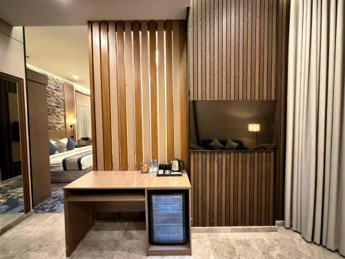 a hotel room with a bed and a desk with a television at Mora Hotel in Jeddah