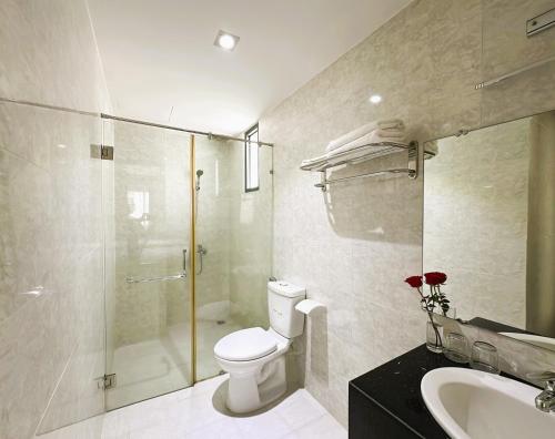 a bathroom with a toilet and a shower and a sink at Zesty Hostel & Bistro in Nha Trang
