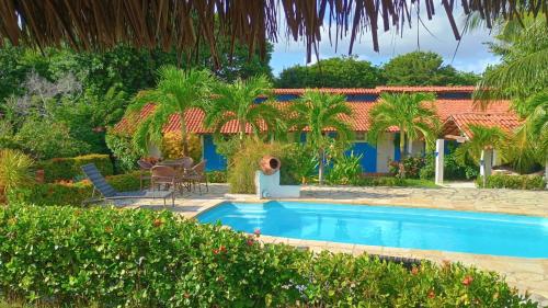 a villa with a swimming pool and a house at Pousada dos Mundos1 in Conde