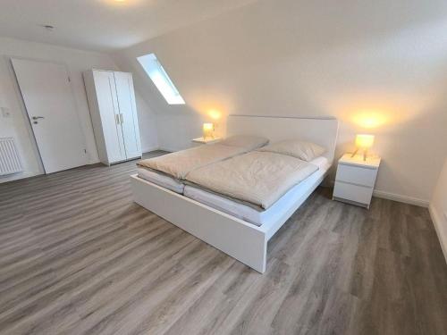 a bedroom with a bed and two lights on two tables at Ferienwohnung-Heide-3 in Walsrode