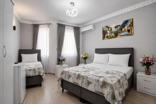 a bedroom with two beds and two windows at Terrace Hotel in Istanbul