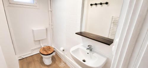 a white bathroom with a sink and a toilet at Parc Exposition, Zénith, Stade Sotteville Rouen - Linge & Ménage Inclus in Sotteville-lès-Rouen
