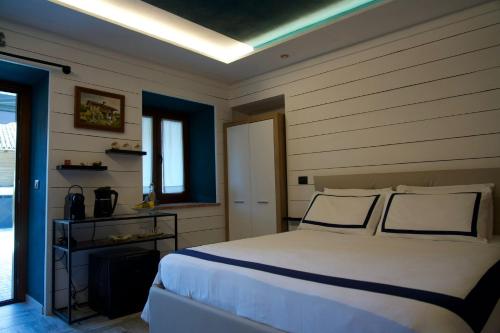 a bedroom with a large white bed with blue walls at B&B ai SILIO in La Morra