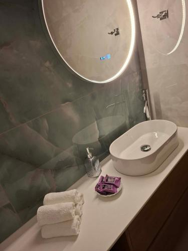 a bathroom with a sink and a mirror at Elina's Era Lounge Apartment in Palekastron