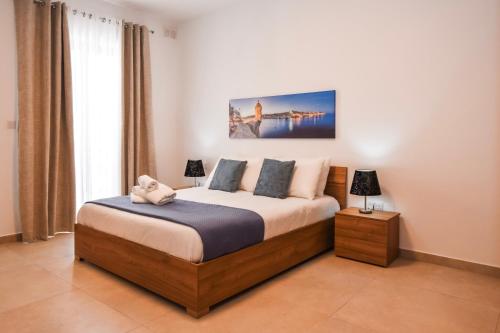 a bedroom with a bed and a large window at BH - Three Bedroom Apartments in Sliema