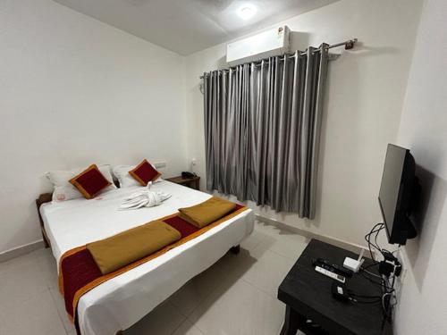 a bedroom with a bed and a television in it at Lotus Leaf Resort, Murud in Murūd