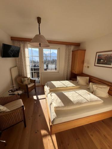 a bedroom with two beds and a large window at Landhaus Lührmann in Ramsau am Dachstein