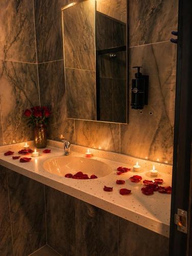 a bathroom with a sink with candles and roses on it at Akman City Hotel in Kuşadası