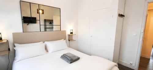 a bedroom with a white bed with a bag on it at Parc Exposition, Zénith, Stade Sotteville Rouen - Linge & Ménage Inclus in Sotteville-lès-Rouen