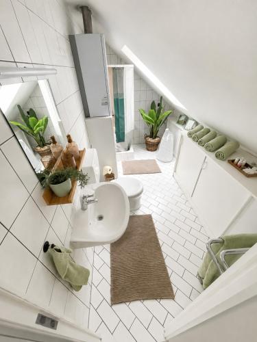 a white bathroom with a sink and a toilet at All Homes Apartments Bad Schallerbach in Bad Schallerbach