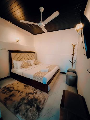 a bedroom with a bed with a ceiling fan at Ranketha Hideout Resorts in Kurunegala