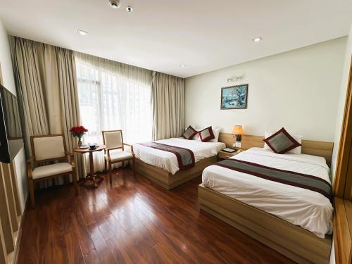 a hotel room with two beds and a window at Zesty Hostel & Bistro in Nha Trang