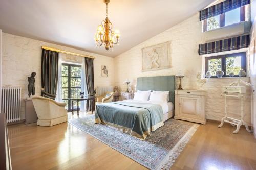 a bedroom with a bed and a table and a chandelier at Corinthian Blue Retreat in Katakoúli