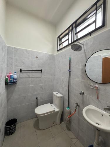 a bathroom with a toilet and a sink and a mirror at D Teratak Homestay in Marang