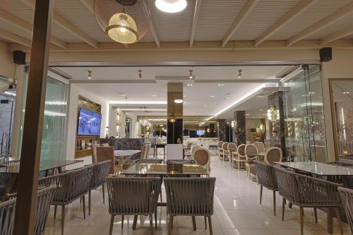 a restaurant with tables and chairs in a building at FEDRA HOTEL in Paralia Katerinis