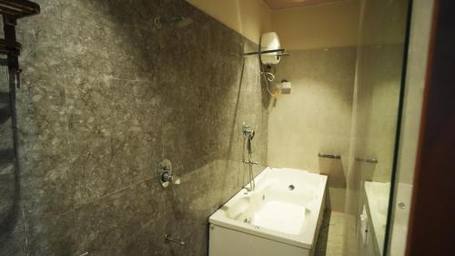 a bathroom with a toilet and a sink and a shower at Hotel Crystal Rajkot in Rajkot