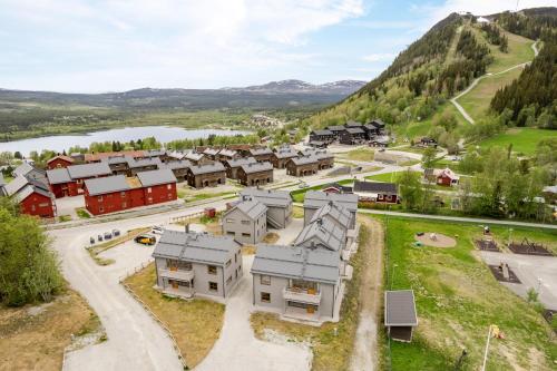 an aerial view of a village with a river and mountains at Funäsdalshöjden - Funäsdalen in Funäsdalen