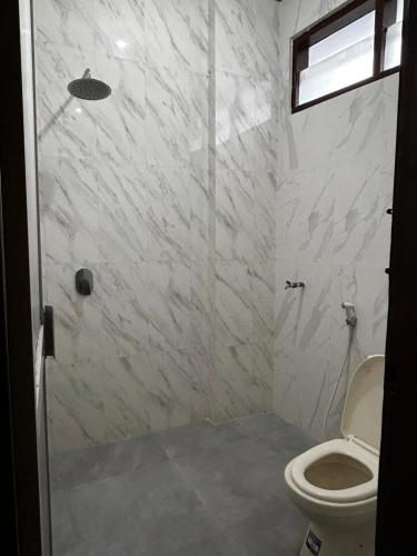 ein Badezimmer mit Dusche und Toilette in der Unterkunft Hotel Pesaban in Tjakranegara