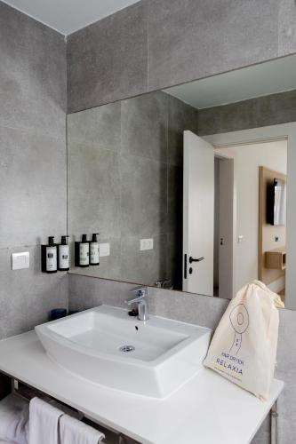 a bathroom with a white sink and a mirror at Relaxia Lanzasur Club - Aqualava Water Park in Playa Blanca