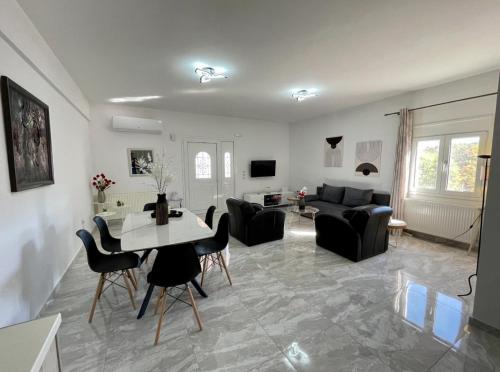 a living room with a couch and a table and chairs at Anemomilos in Samos