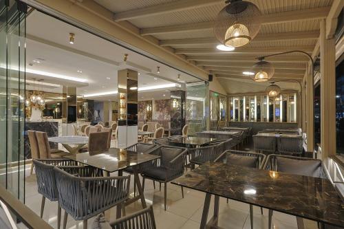 a restaurant with tables and chairs and windows at FEDRA HOTEL in Paralia Katerinis