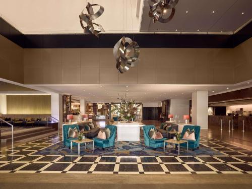 eine Hotellobby mit blauen Stühlen und einem Schachbrettboden in der Unterkunft Sofitel Brisbane Central in Brisbane
