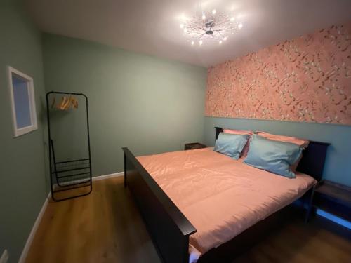 a bedroom with a bed with a pink wall at B&B Historia in Melderslo